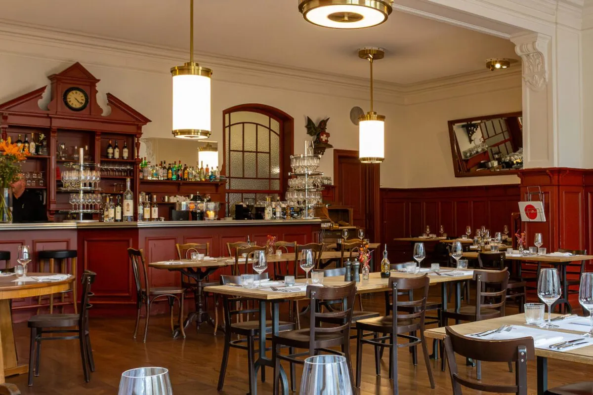 Gastraum des Restaurants zur Mägd mit Holztäfer, Hängelampen und gedeckten Tischen